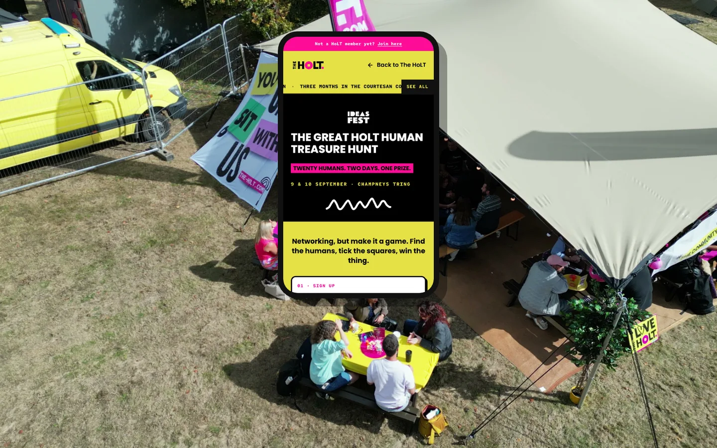 The Great HoLT Human Treasure Hunt on a phone, over a drone shot of the HoLT tent at Ideas Fest.